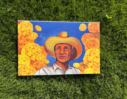 Colorful painting of a man in a hat within a cempasuchil field.